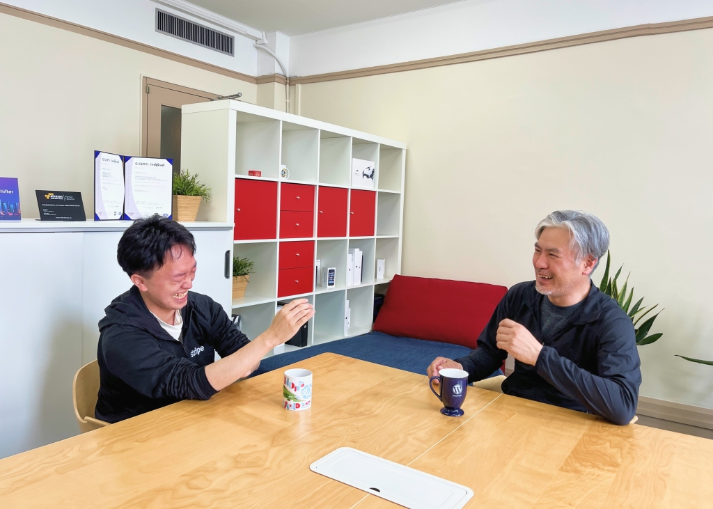 インタビュー中の岡本秀高さんとデジタルキューブ代表の小賀さん写真2